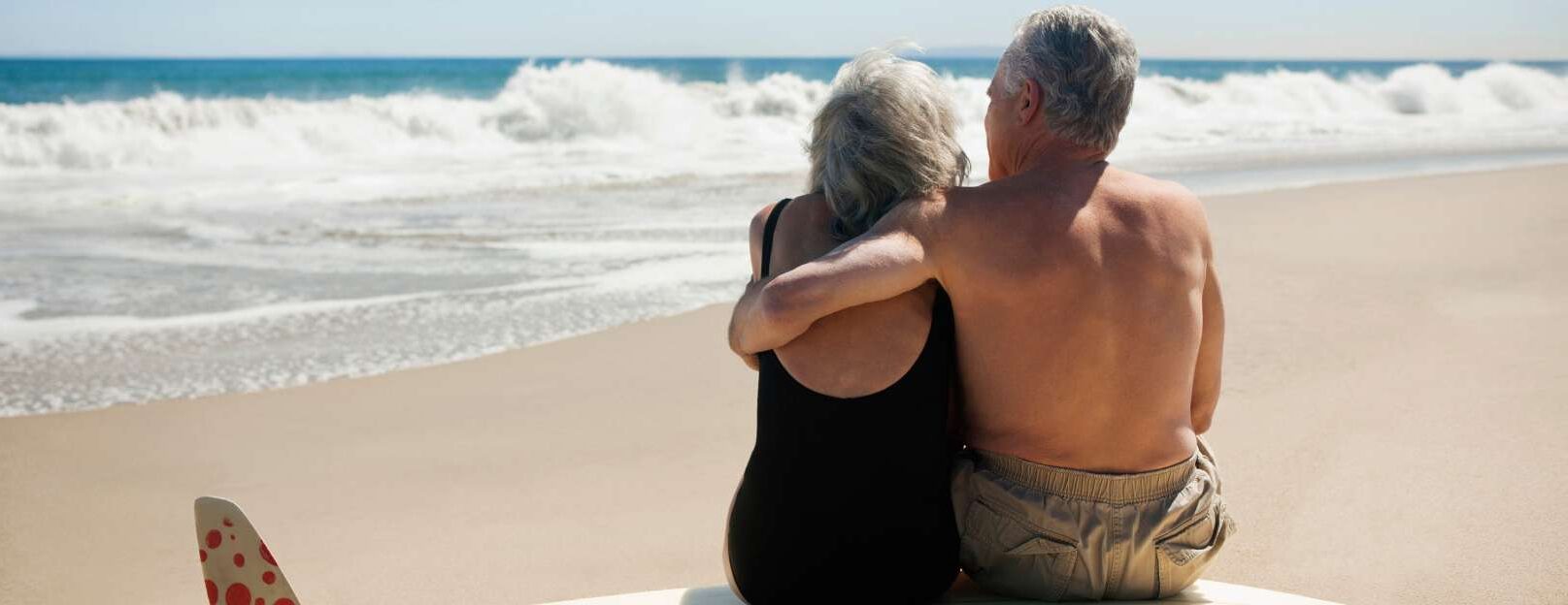 senioren-sitzen-auf-surfbrett-am-strand